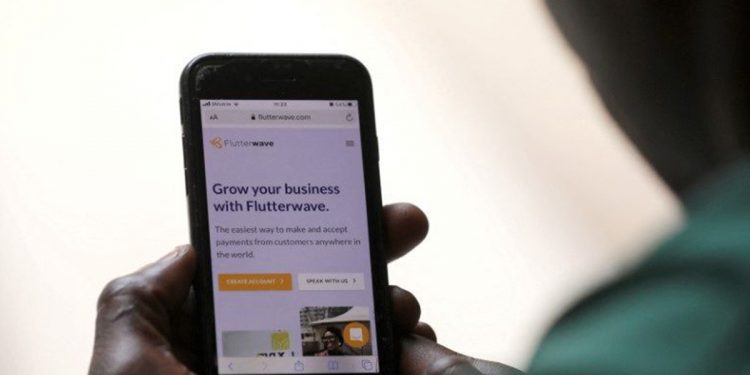 A man poses as he displays the Flutterwave homepage on a mobile phone screen in Abuja, Nigeria January 21, 2020. REUTERS/Afolabi Sotunde/File Photo