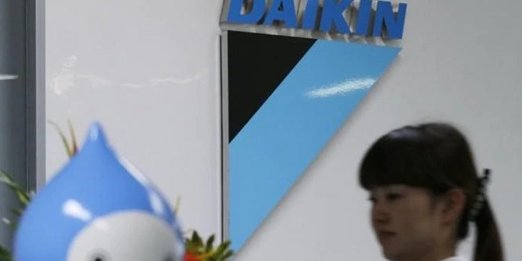 A staff walks past a logo of Daikin Industries Ltd and the company mascot "Pichon" at the company's office in Tokyo August 29, 2012. REUTERS/Toru Hanai